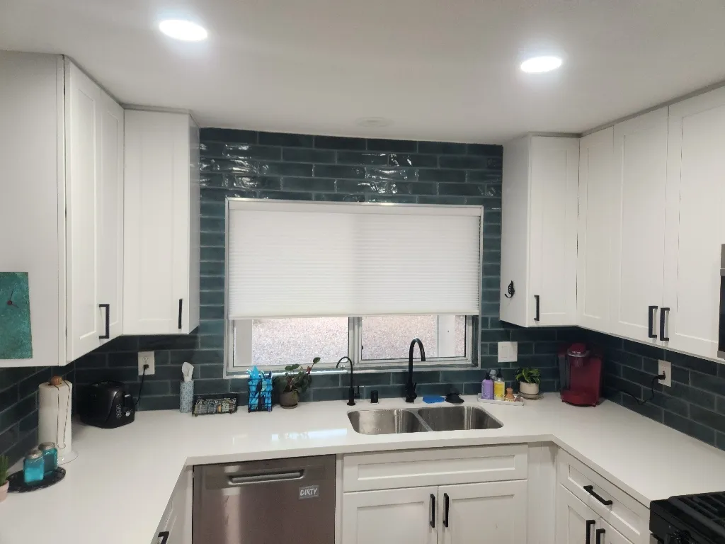 Finished kitchen remodel with white cabinets and tile backsplash