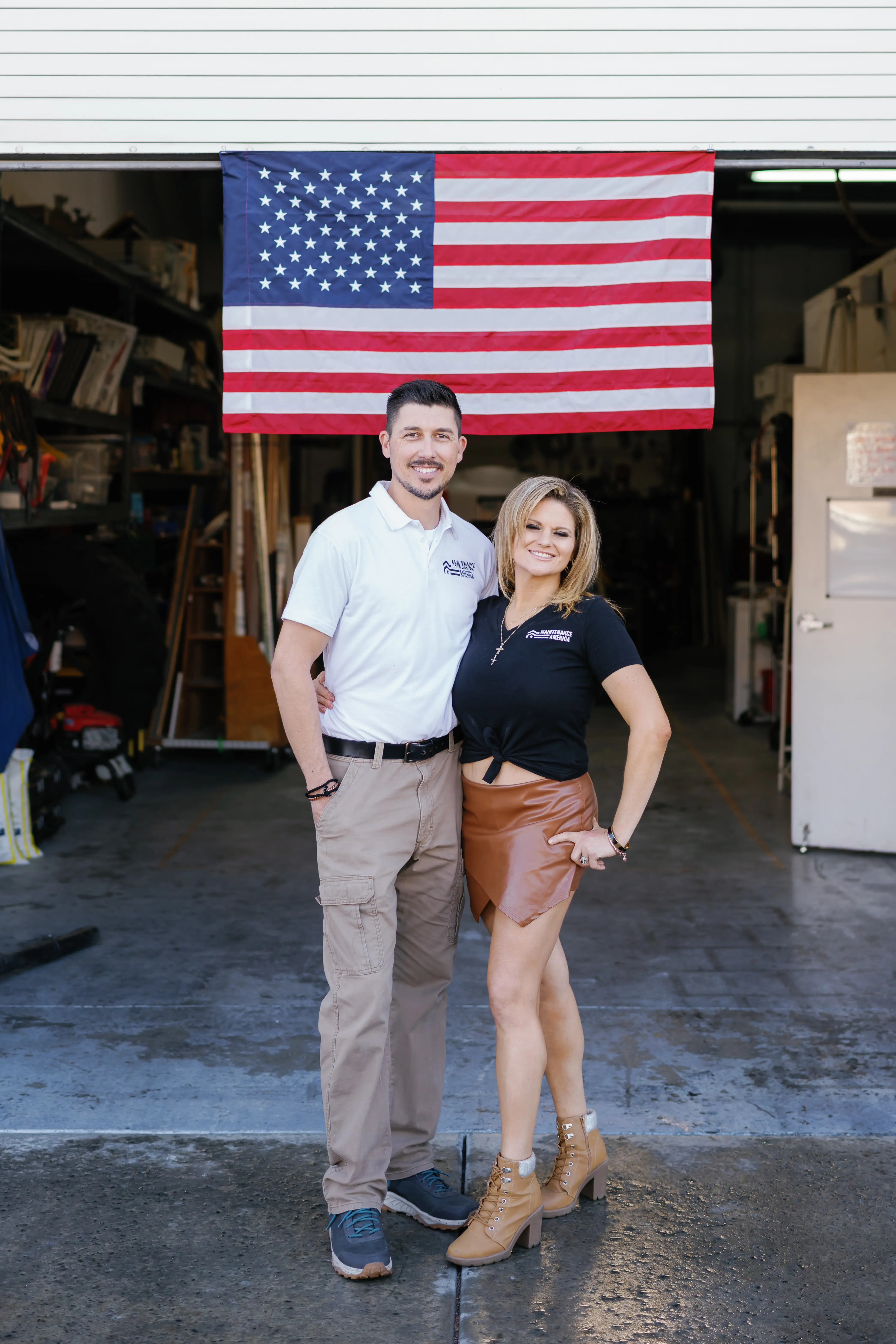 Tony and his wife in front of the Maintenance America trucks and American flag